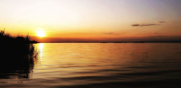 Scenic view of sea against romantic sky at sunset