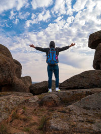 Traveler hiker man backpack raised hands on mountain cloudy sky.  active lifestyle solo backpacking 