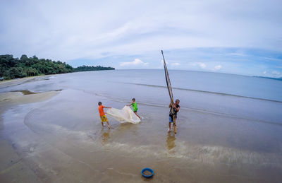 People on beach against sky