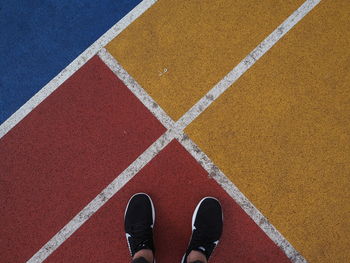 Low section of person standing on sports track