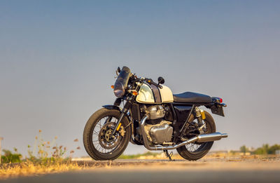 Man riding motorcycle on road against sky