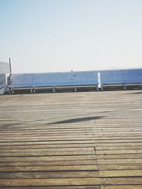 Boardwalk on beach against clear sky