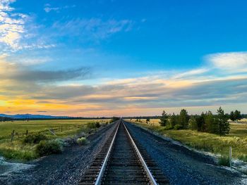 Surface level of railway tracks on field against sky