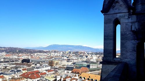 Buildings in city against clear blue sky