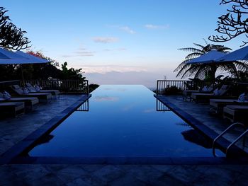 Swimming pool by sea against sky
