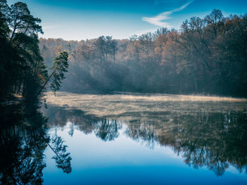 Lonely lake in the morning light with mist over the reflecting water