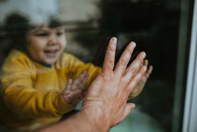 Close-up of woman hand on glass window