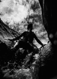 Low angle view of men on mountain against sky