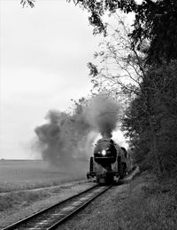 Train on railroad track amidst trees against sky