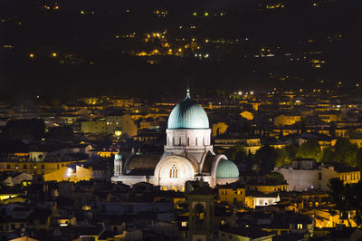 An illuminated place of worship distincting itself from its surroundings 