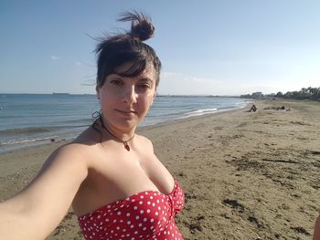 Portrait of woman standing on beach against sky