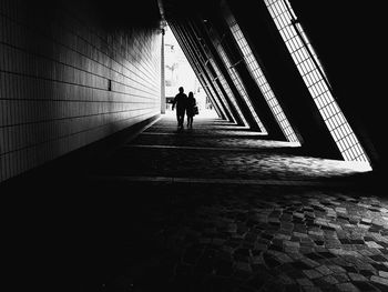 Silhouette couple walking on covered walkway