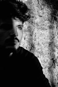 Portrait of young man standing against wall