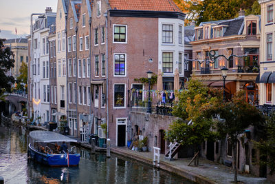 Sightseeing boat tour on the oudegracht canal in utrecht city centre. autumn evening.