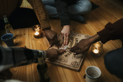 Multiracial male and female friends using ouija board in house