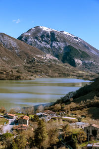 Scenic view of lake by mountains against sky