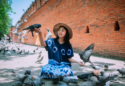 Young woman playing with pigeons