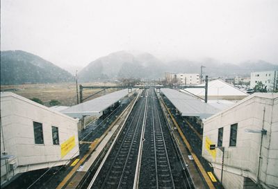 Railroad tracks by mountain against sky