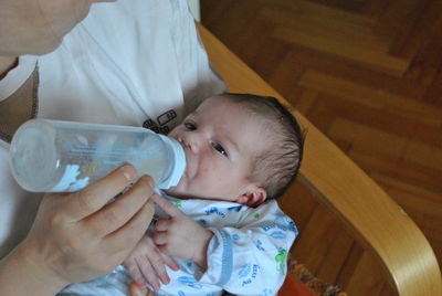 Close-up of mother feeding baby at home