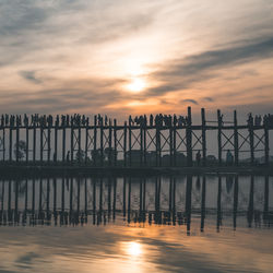 Pier on sea at sunset