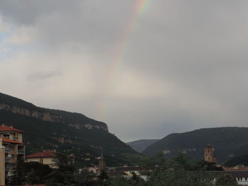 Scenic view of rainbow over town against sky