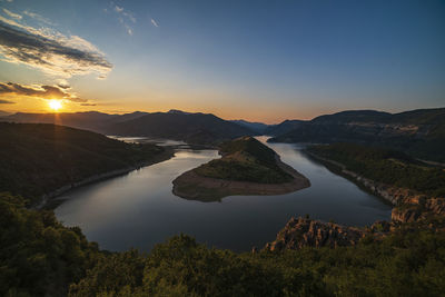 Scenic view of river against sky during sunset