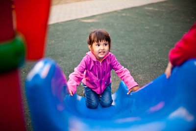 Cute girl playing on slide in playground