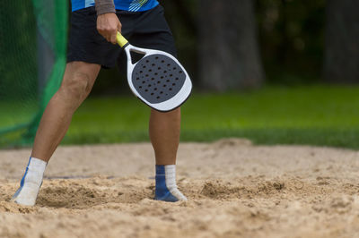 Low section of man playing on sand