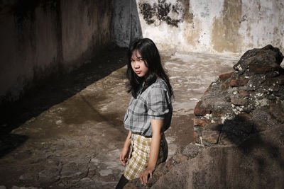 Full length of woman standing against wall