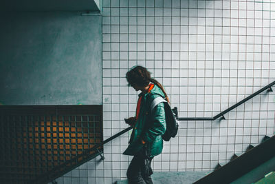 Side view of man working against wall