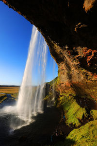 Scenic view of waterfall against sky