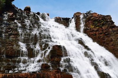 Scenic view of waterfall against sky