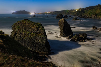 Rocks on beach against sky
