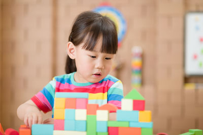 Young girl playing creative toy blocks for home schooling