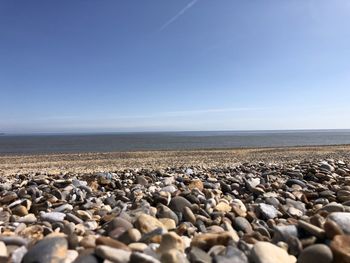 Surface level of stones on beach against sky