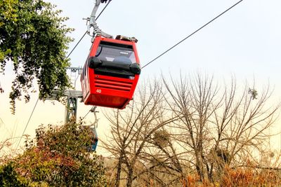 Low angle view of overhead cable car against sky