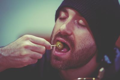 Close-up of man eating olive