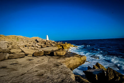 Scenic view of sea against clear blue sky