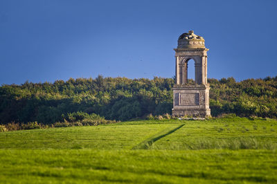 Built structure on field against clear sky