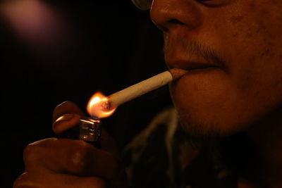 Close-up of man smoking lighter