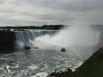 Scenic view of waterfall against sky