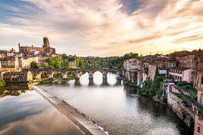 Bridge over river against buildings in city