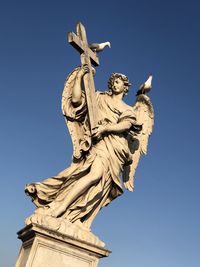 Low angle view of statue against blue sky