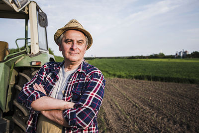 Farmer standing next to tractor at a field