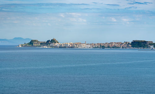 Scenic view of sea by city against sky