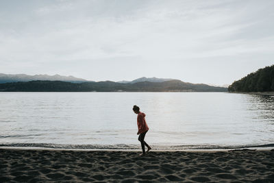 Full length of man standing on lake against sky