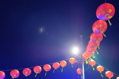 Low angle view of balloons against sky at night