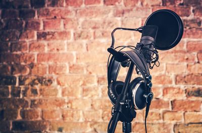 Close-up of microphone against brick wall