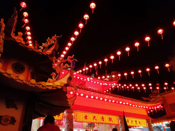 Illuminated carousel in amusement park at night