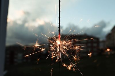 Close-up of illuminated sparkler in city